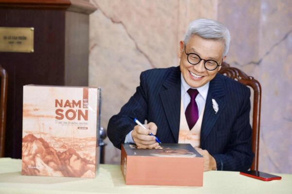 Tác giả Ngô Kim Khôi bên bộ sách “NAM SƠN (1899–1973), Di sản Mỹ thuật Đông Dương qua tư liệu, lưu trữ và báo chí”